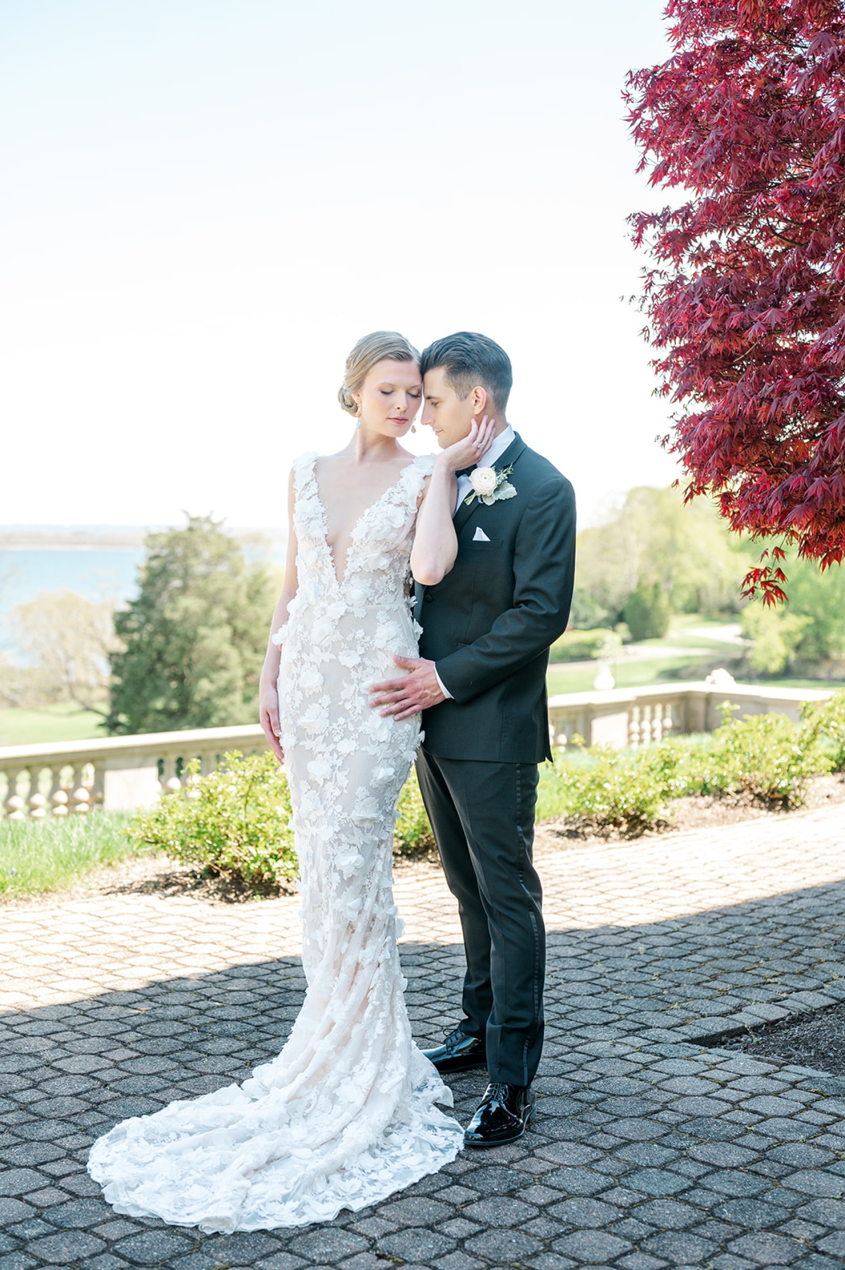 a bride and groom snuggle and hold each other on a stone patio at their aldrich mansion wedding