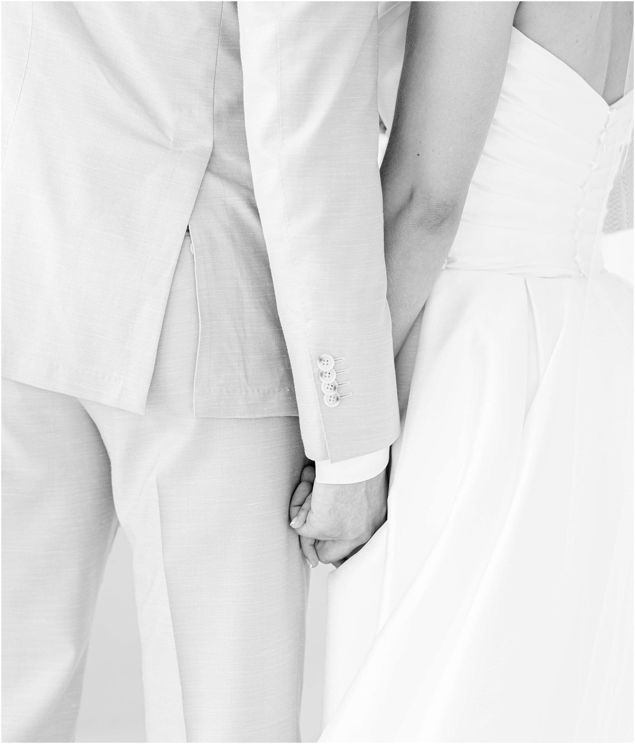 Black and white details of newlyweds holding hands